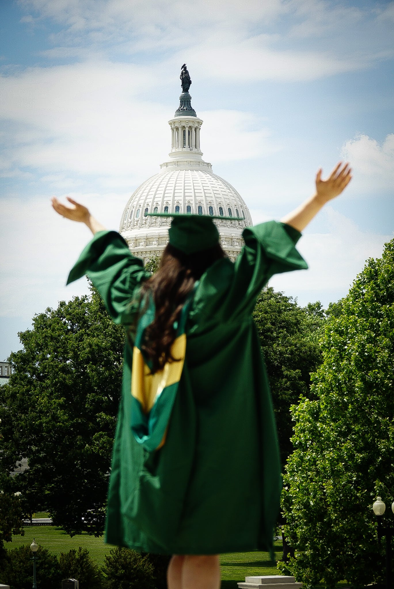 Graduate in cap and gown smiling outdoors