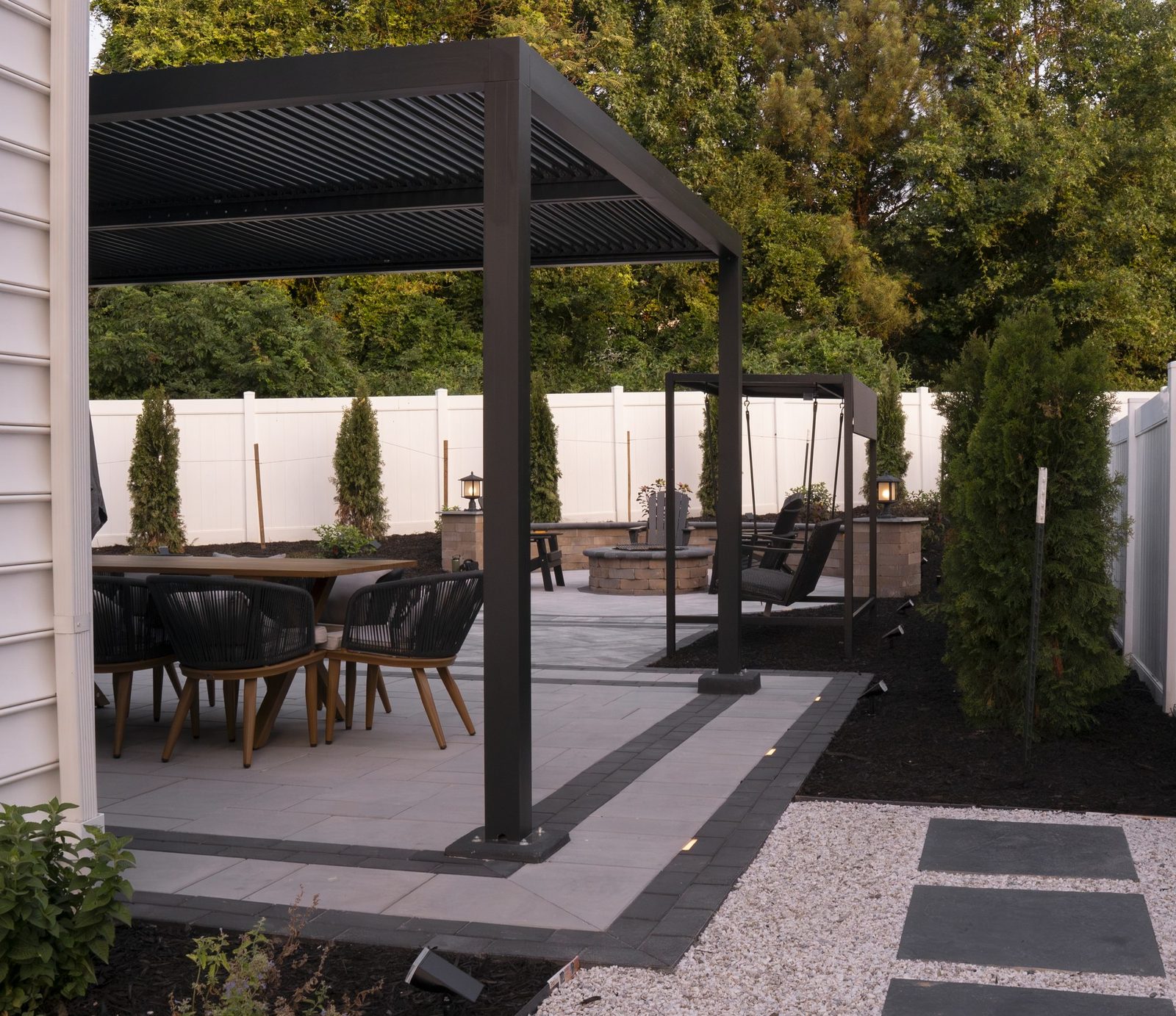 Renovated paver patio with a louvered pergola, dining set and fire pit